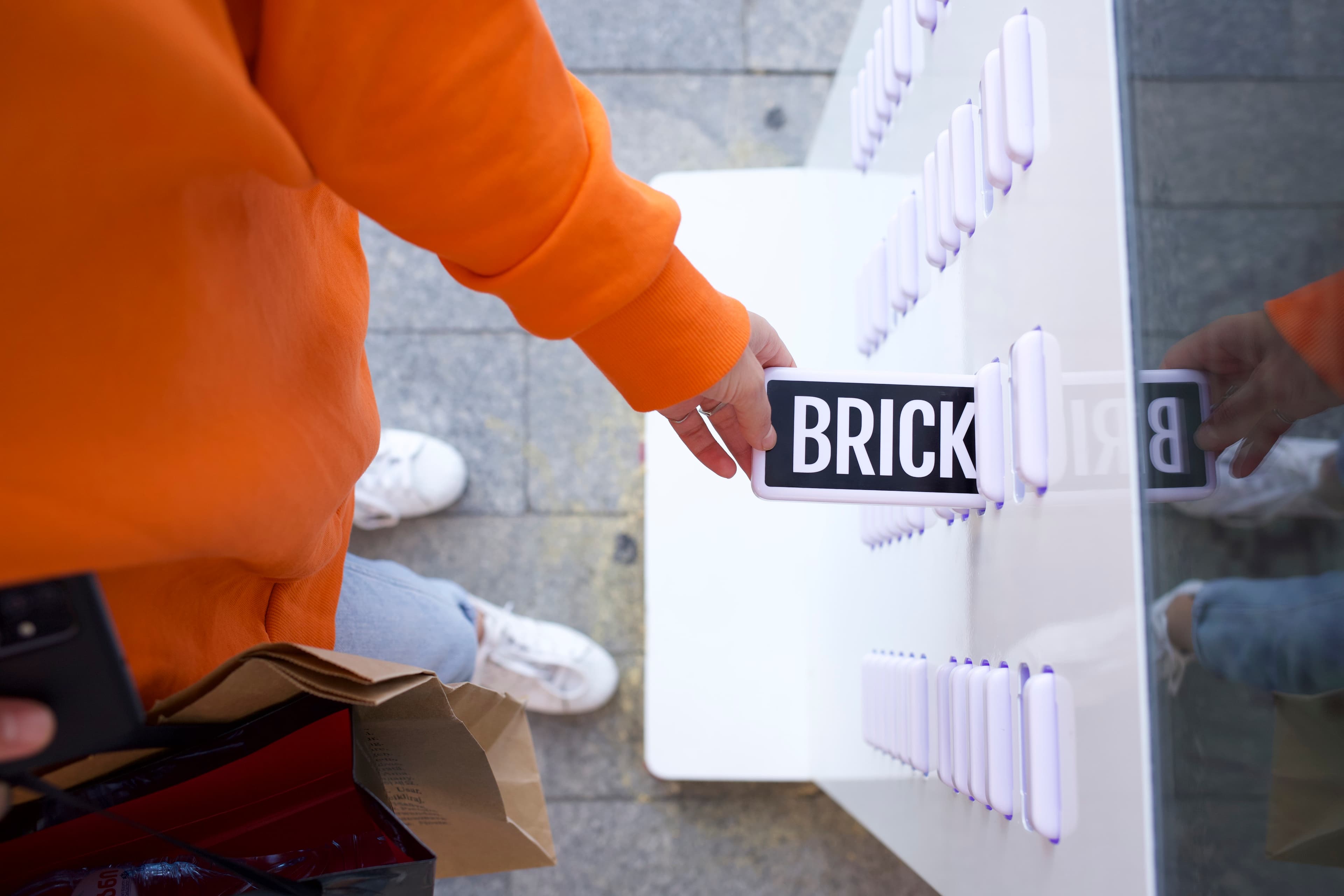 O mână care primește o bancă de alimentare Brick de la o stație